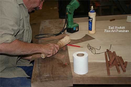 Earl pegging tenons on one end of table